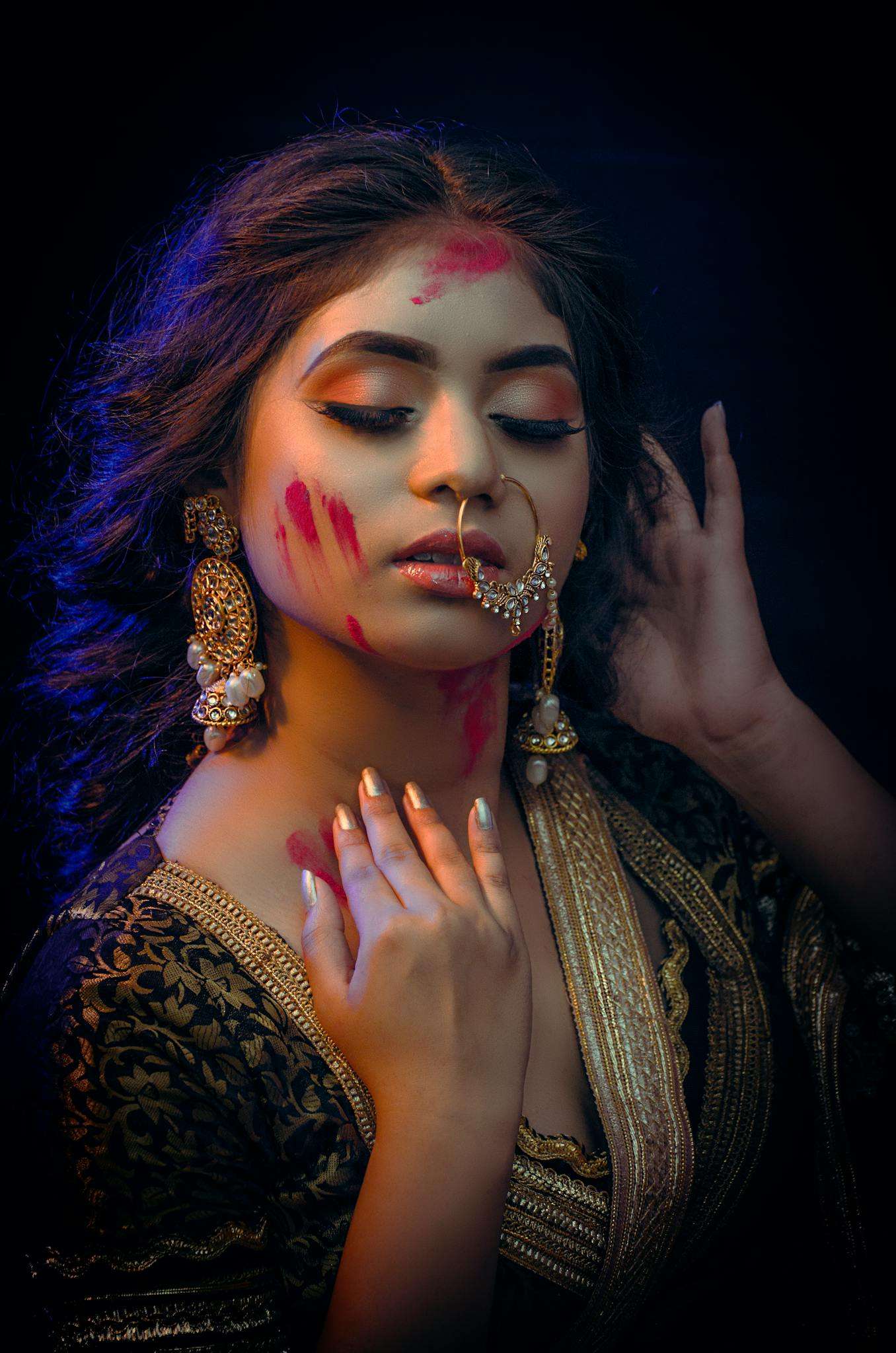 A young Indian woman adorned with traditional jewelry, posing gracefully.