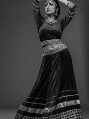 Black and white photo of a woman in a traditional Indian dance pose, studio setting.